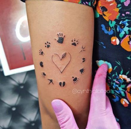 a person with a tattoo on their arm and paw prints in the shape of a heart