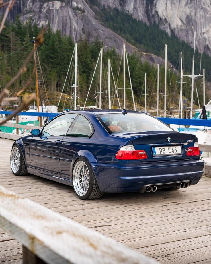 a blue car parked on top of a wooden dock