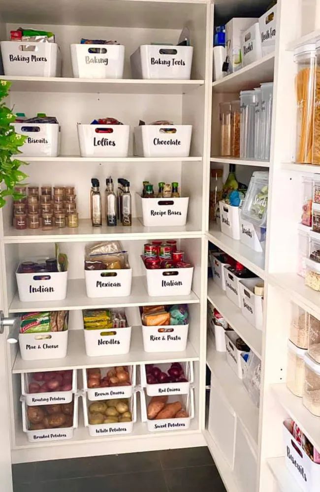 an organized pantry with white bins filled with food