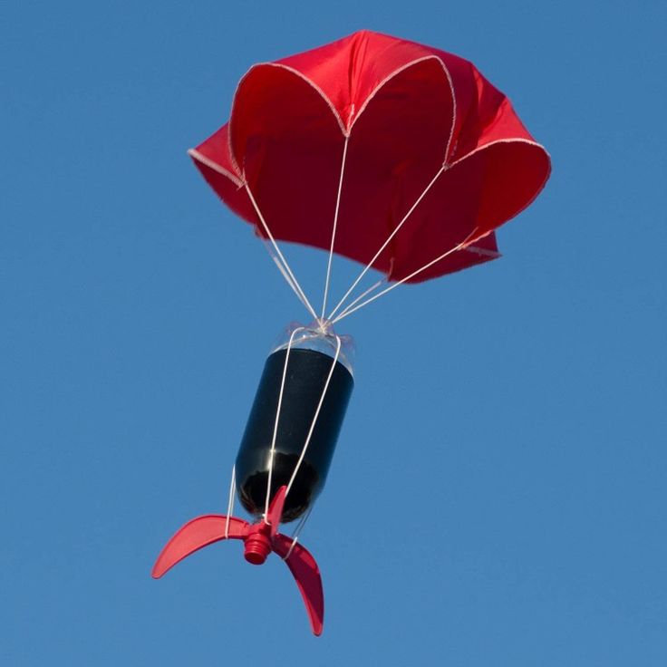 a red and black heart shaped kite flying in the air with a blue sky behind it