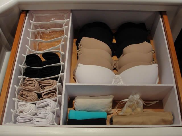 an open drawer with clothes and other items in it