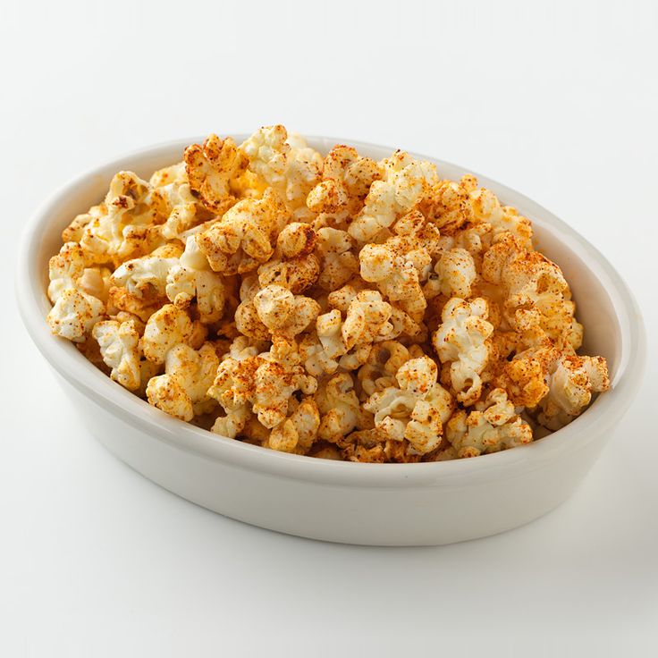 a white bowl filled with popcorn on top of a table