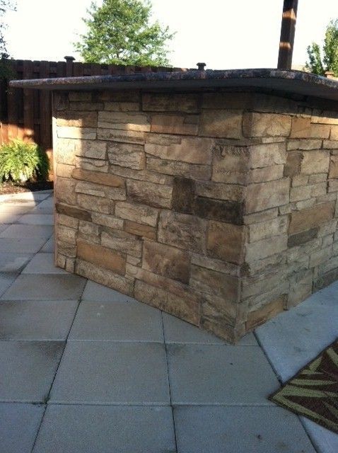 an outdoor bar made out of stone on a patio