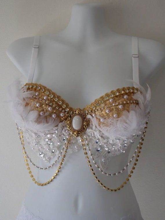 Unleash your inner celestial beauty with our Divine Angel-themed Crystal Bra. This enchanting creation is a true testament to ethereal grace and captivating allure. Adorned with delicate crystal chains that shimmer and sparkle, this bra radiates an otherworldly charm. The intricate arrangement of pearls adds a touch of sophistication and opulence, elevating the design to heavenly heights. Golden trim and sequins embellish this celestial masterpiece, infusing it with a radiant glow and a sense of Bedazzled Bra, Decorated Bras, Bling Bra, Crystal Bra, Diy Bra, Womens Costumes, Rhinestone Bra, Edc Outfits, Rave Costumes