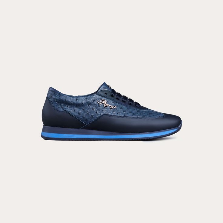 All-blue laced runner sneakers. The sneakers are made with a rich ostrich/leather material by the finest artisans who focus on every detail with close attention. A material that is made to last. Ostrich mid-section, that is finished off with the distinctive Reggenza tag. You'll be reminded of your elegance with ease. Rubber soles, ensuring your comfort at all times. A sneaker that is flawless for both formal and casual occasions. Pair them up with a pair of denim jeans, or some casual trousers. Blue Leather Wingtip Sneakers, Elegant Blue Low-top Sneakers, Luxury Blue Sneakers With Perforated Toe Box, Luxury Blue Sneakers With Textured Sole, Crocodile Leather Shoes, Ostrich Leather, Sneakers Blue, Casual Trousers, Green Leather