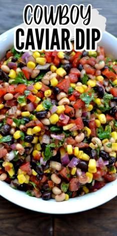 a white bowl filled with corn and black - eyed peas next to a wooden table