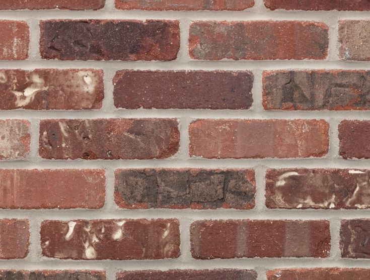 a brick wall that is made out of red bricks and has some white paint on it