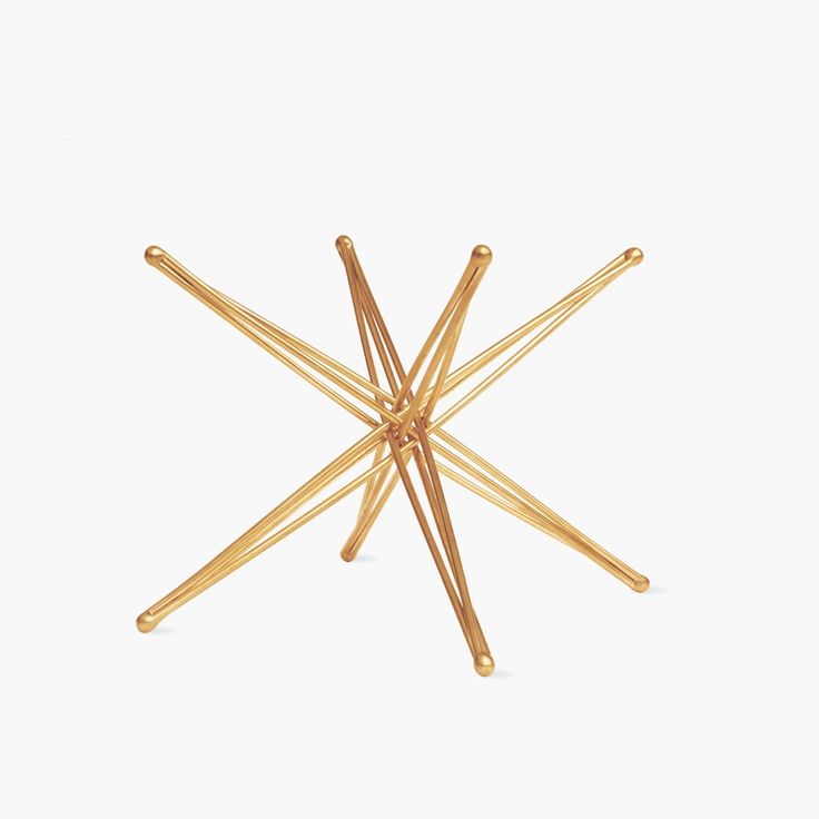 a gold plated star shaped object with four small sticks sticking out of the center