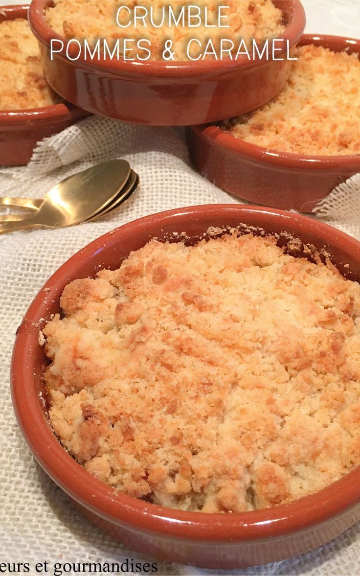 two bowls filled with crumbled food on top of a table next to silverware