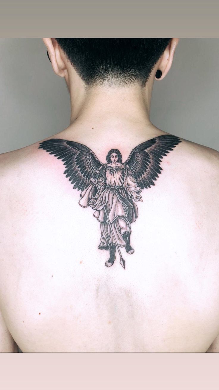 the back of a man's neck with an angel tattoo on his upper part