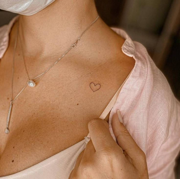 a woman with a heart tattoo on her chest