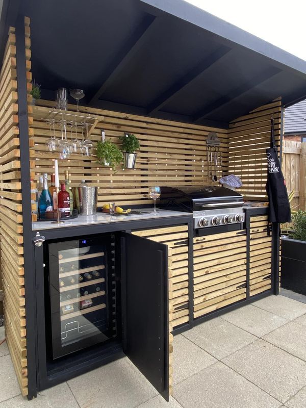 an outdoor kitchen made out of wooden slats