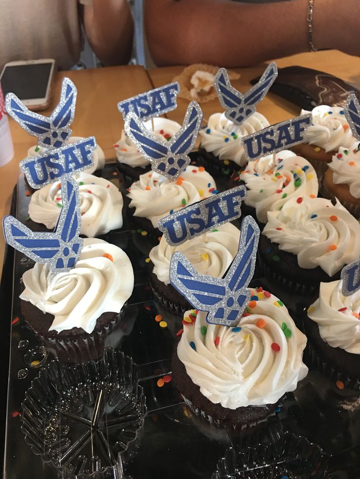 cupcakes with frosting and decorations are on a tray