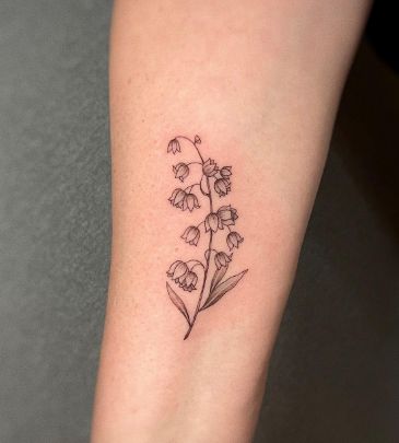 a small flower tattoo on the right arm and leg, it looks like flowers are growing out of the ground