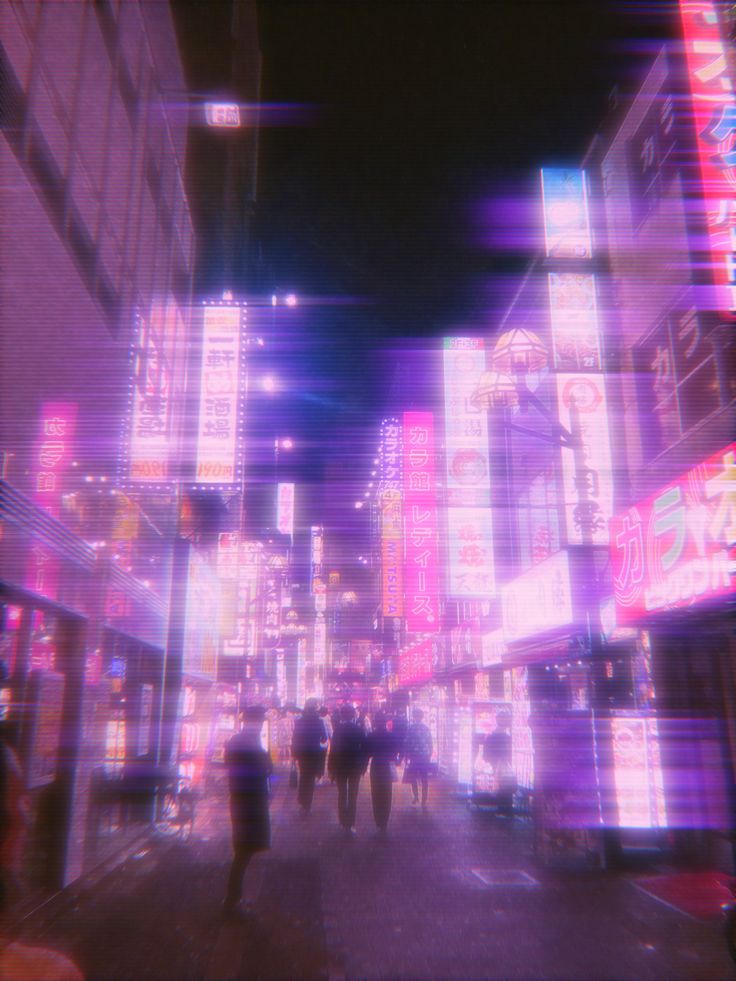 people walking down the street at night with neon lights on buildings and billboards in the background