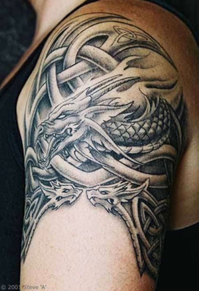 a man's arm with a dragon tattoo on the back of his shoulder and chest