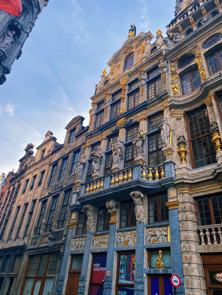 an ornate building with many windows and statues on the front, against a blue sky