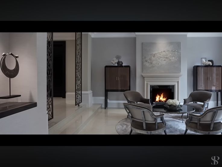 a living room filled with furniture and a fire place in the middle of it's wall