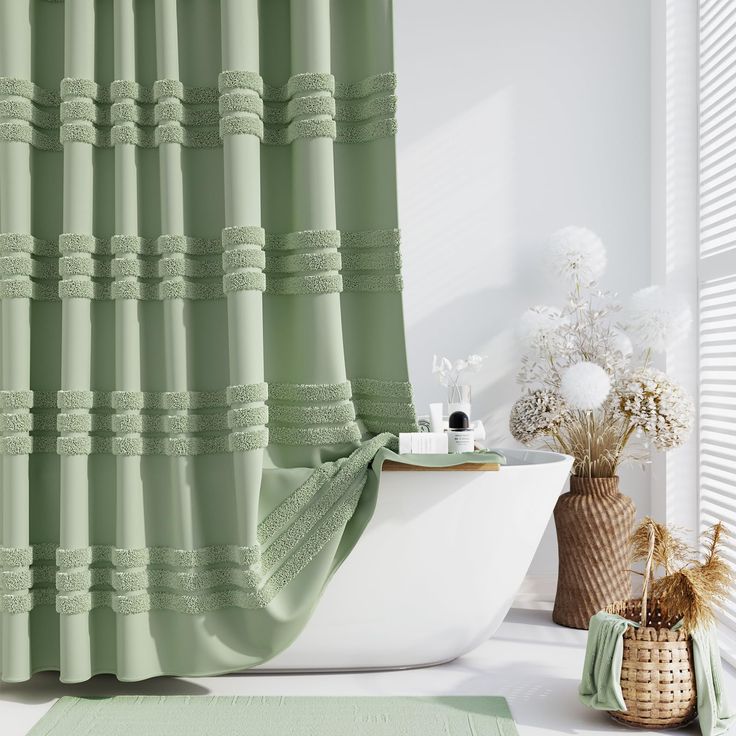 a green shower curtain in a bathroom next to a white bathtub and vase with flowers