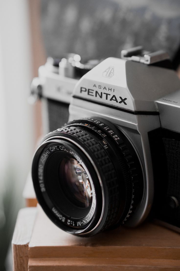 an old camera sitting on top of a wooden table