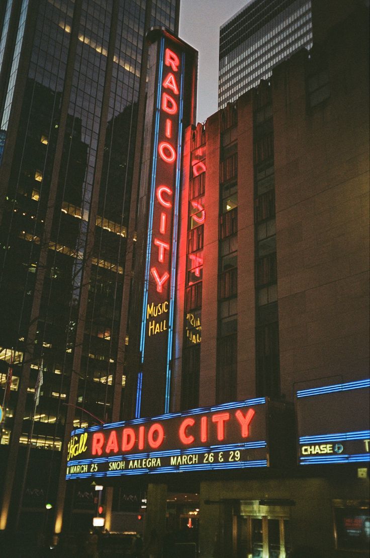 the radio city sign is lit up at night