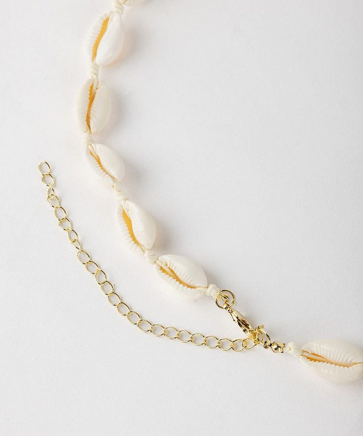 Designed for both fashion + function, this natural Cowrie shell band will add a touch of beachy texture to your fit + the best part is, It doubles as a shell necklace or bracelet. Summer Beach Strand Jewelry, Beaded Beachy Jewelry For The Beach, Beaded Strand Jewelry For Beach, Beaded Strand Jewelry For The Beach, Adjustable Gold Shell Necklace For Summer, Beachy Cowrie Shell Jewelry For Vacation, Beachy Shell Jewelry For Summer, Summer Adjustable Strand Necklace, Beaded Shell Strand Necklace