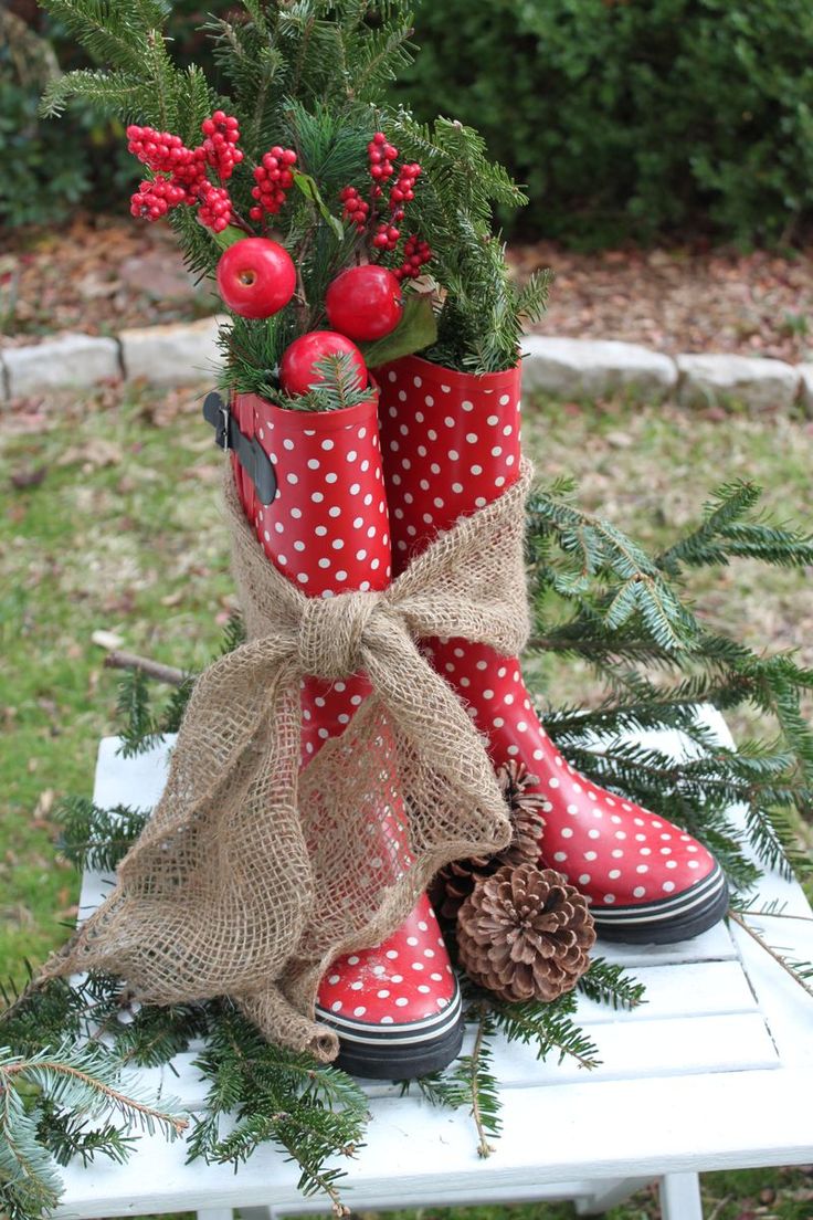 a pair of red boots sitting on top of a white table covered in christmas decorations