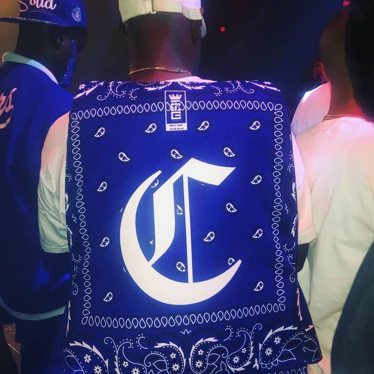 the back of a man wearing a blue bandana with an illuminated letter on it