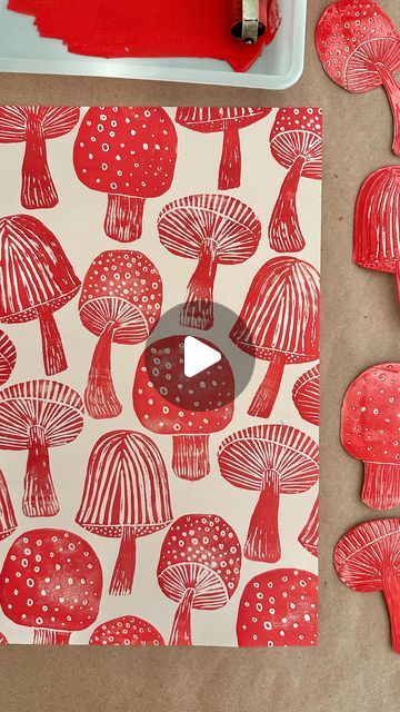 red mushrooms on white paper next to paintbrushes and some other crafting supplies