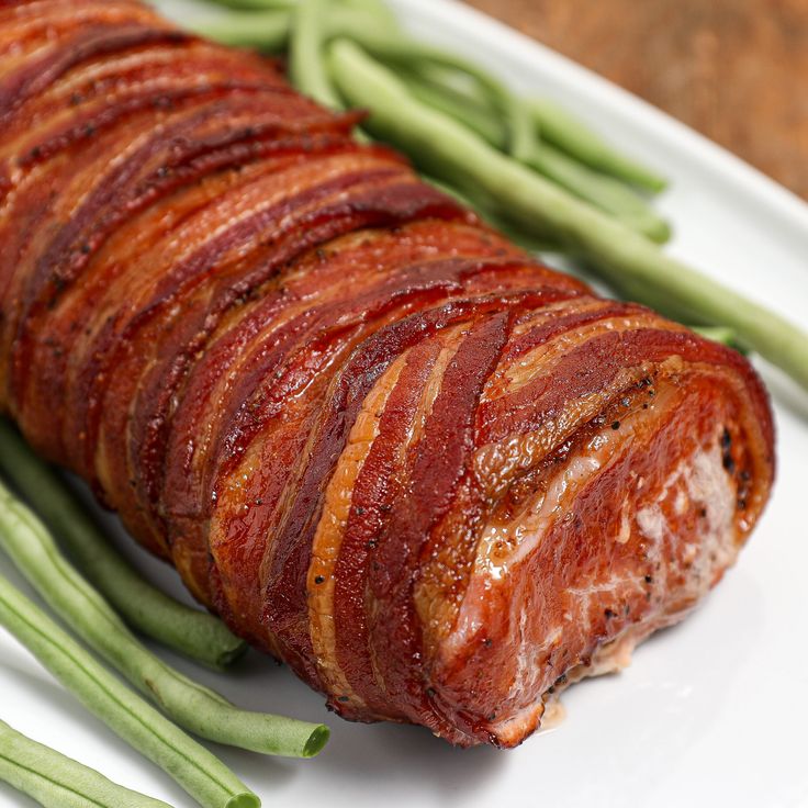 some green beans and bacon on a white plate