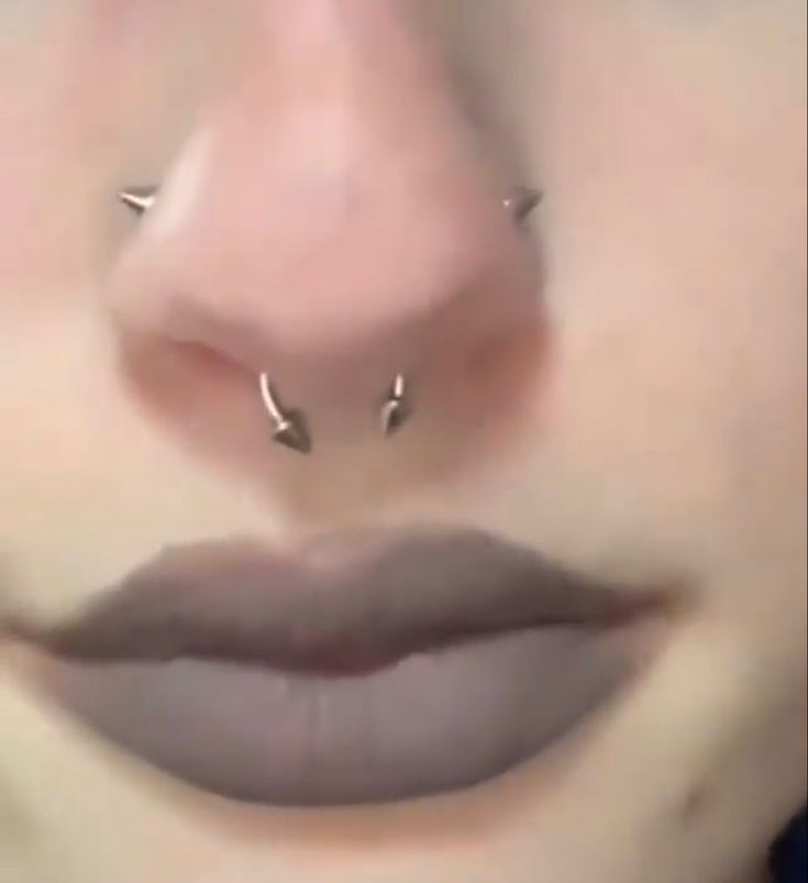 a woman's nose has three piercings on it