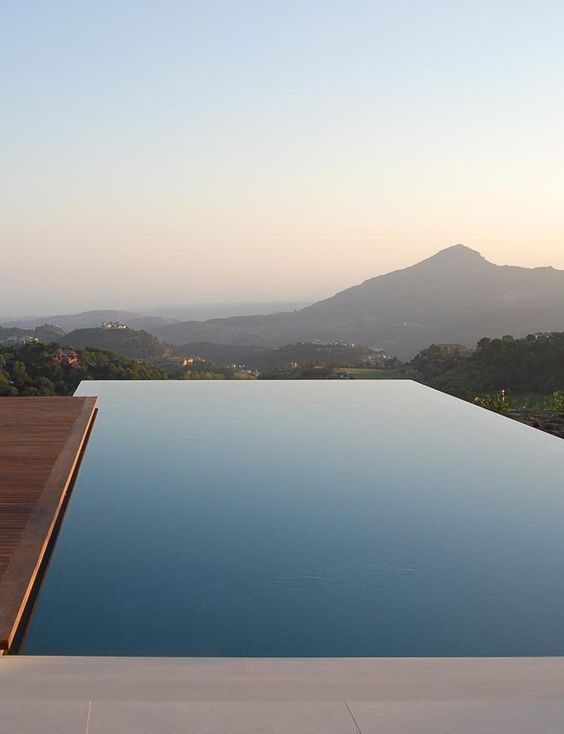 an empty swimming pool with mountains in the background