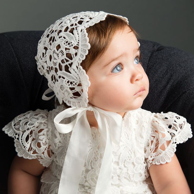 "Lola Lace Bonnet | Ivory Lace **PLEASE NOTE, THIS ITEM IS NOT INTENDED AS/FOR INFANT SLEEPWEAR** The Lola lace bonnet is a beautifully detailed and designed bonnet for your baby girl. This lace bonnet is uniquely designed with richly embroidered light ivory lace and cotton floral edge lace at the back. The specially designed keyhole back is adjustable, allowing you to tie it tighter or relax the ribbon for a near custom fit. The silk ribbon ties under her chin add a darling bow, while also keep White Elegant Baptism Dress For First Birthday, Elegant White Baptism Dress For First Birthday, Blessing Gown, Lace Bonnet, Baptism Gown, Baptism Outfit, Lace Booties, Christening Gown, Christening Outfit