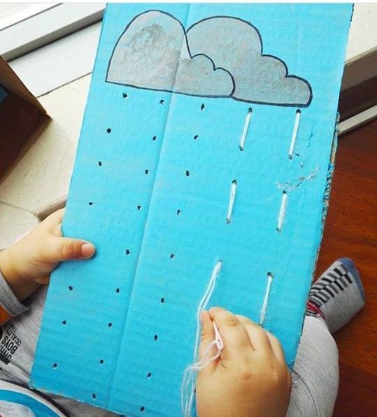 a child is drawing on a piece of paper that has rain coming out of it