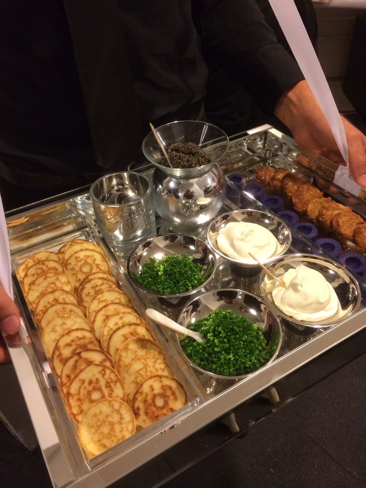 a buffet tray filled with different types of food and condiments, including pita bread