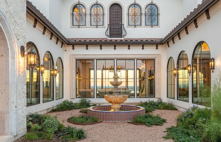 a large white building with a fountain in the middle of it's front yard