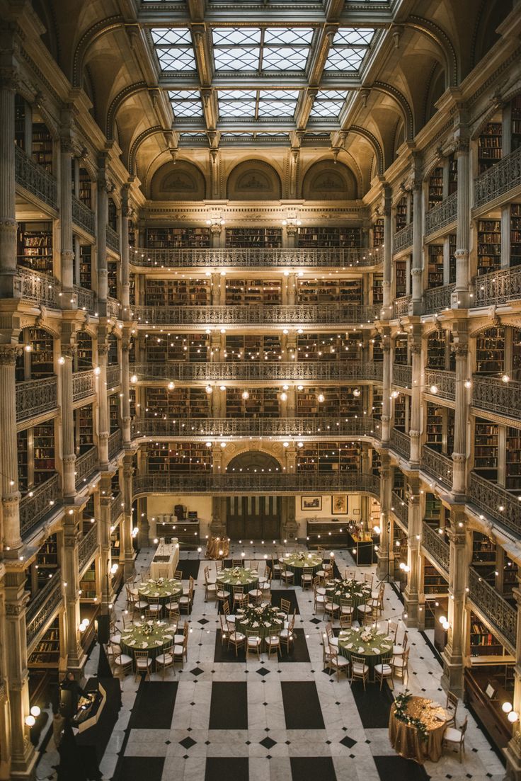 the interior of a large library with tables and bookshelves on both sides of it