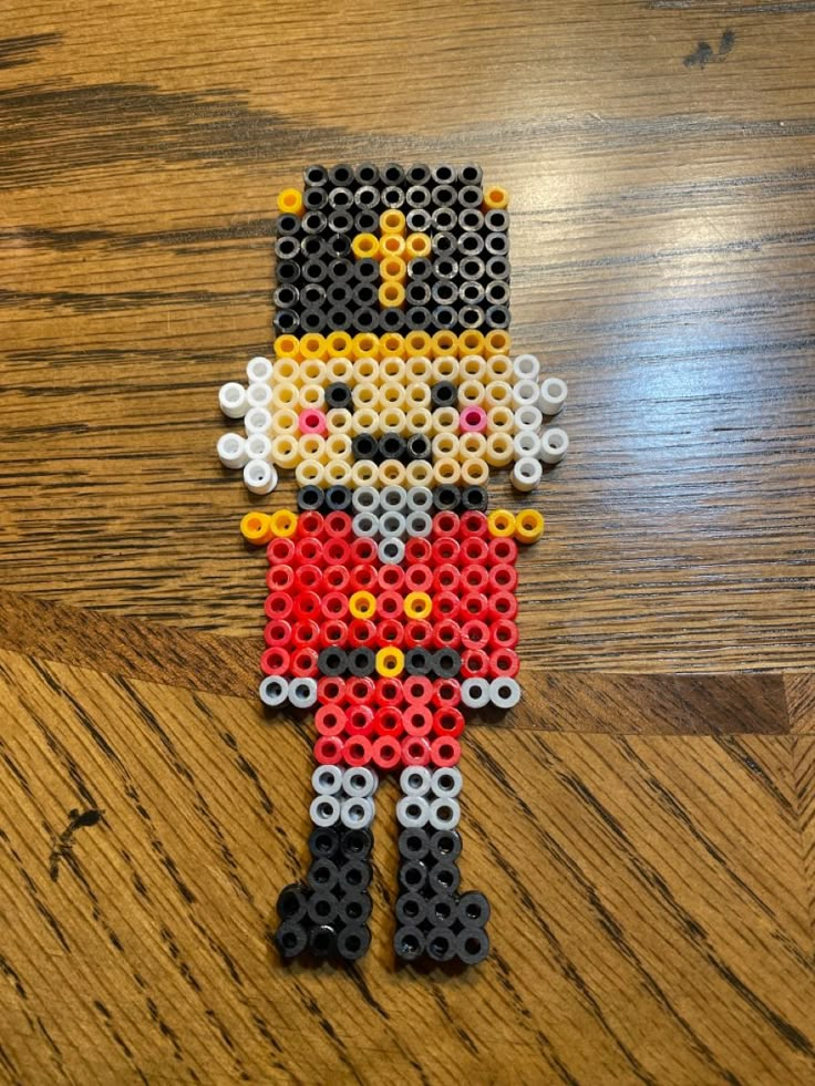 an image of a beaded figure made out of legos on a wooden table