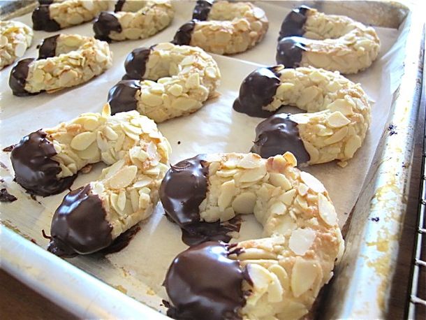 chocolate covered doughnuts sitting on top of a cookie sheet in a baking pan