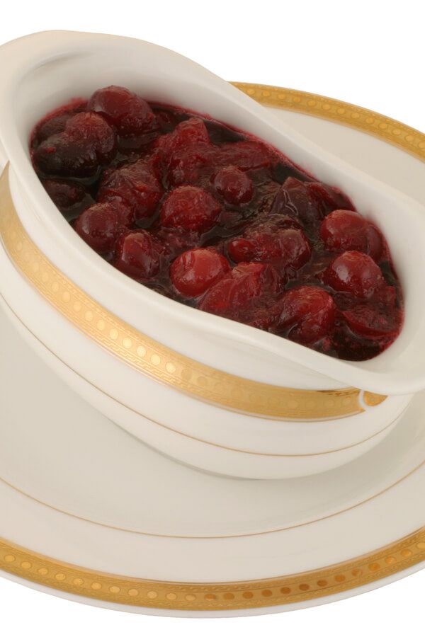 a white bowl filled with cranberry sauce on top of a yellow and white plate