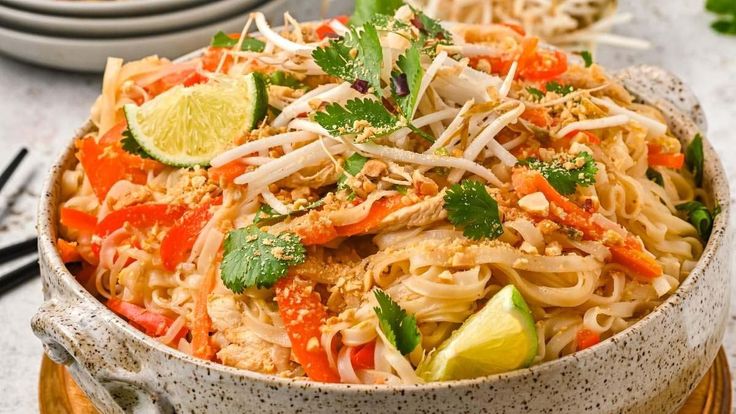 a bowl filled with noodles and vegetables on top of a table