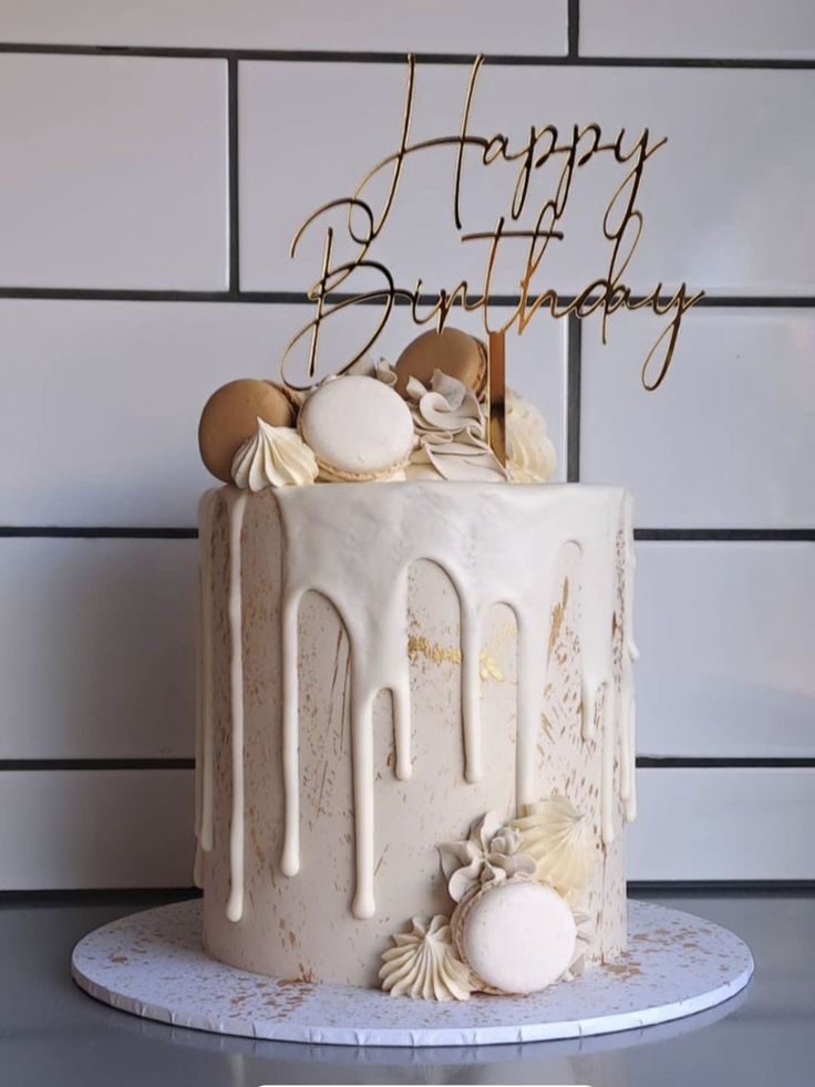 a birthday cake with white icing and seashells on top, sitting on a table