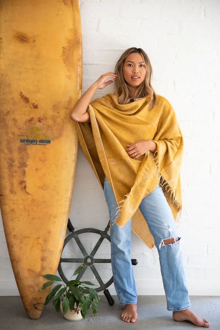 This honey-hued poncho is handwoven in Nepal on majestic wooden looms using a soft, unique yarn and finished with perfectly twisted tassels. Sewn in Western Australia, this piece is perfect for chilly mornings or cool beach evenings. It's easy to style this poncho. Wear it with the v-neck at the front or diagonal for a different look. One size fits most. Approximate size overall is 30 x 74 inches. Wash by hand in cold water and dry with care. Cozy One Size Poncho For Beach, One Size Beach Shawl With Fringe, Bohemian One-size Handwoven Cape, Fall Beach Cape Shawl, One Size Tasseled Shawl For The Beach, Beach Poncho In One Size, Bohemian Handwoven One-size Cape, Beach Shawl With Tassels, Beach Shawl With Tassels One Size