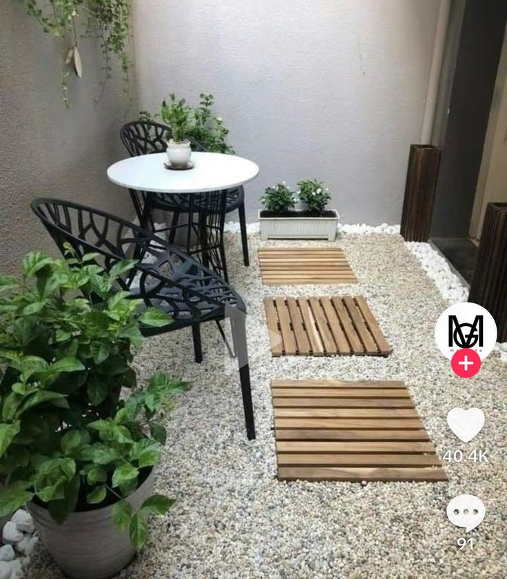 an outdoor patio area with chairs, table and potted plants