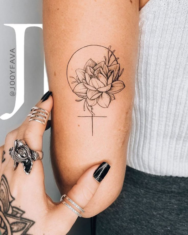 a woman's arm with a flower tattoo on the left side of her arm