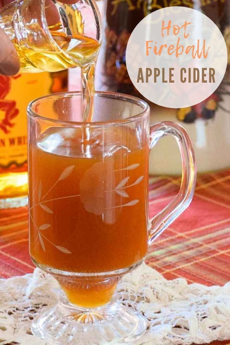 an apple cider being poured into a glass mug