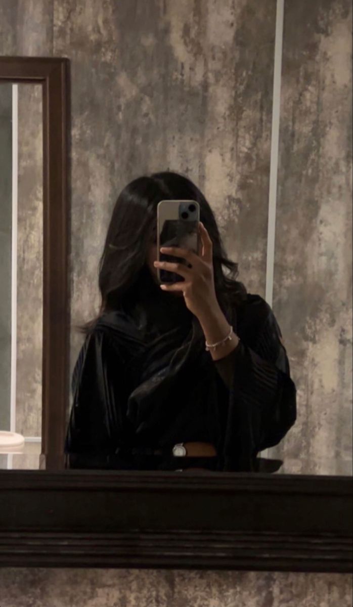 a woman taking a selfie in front of a mirror