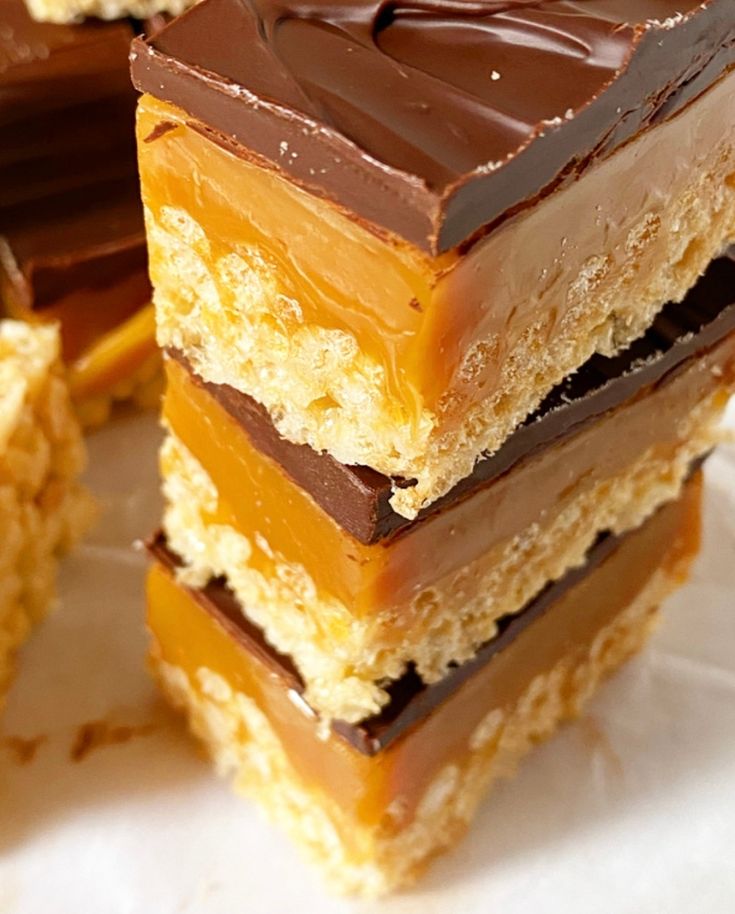 several pieces of chocolate and peanut butter bars stacked on top of each other with one bite taken out