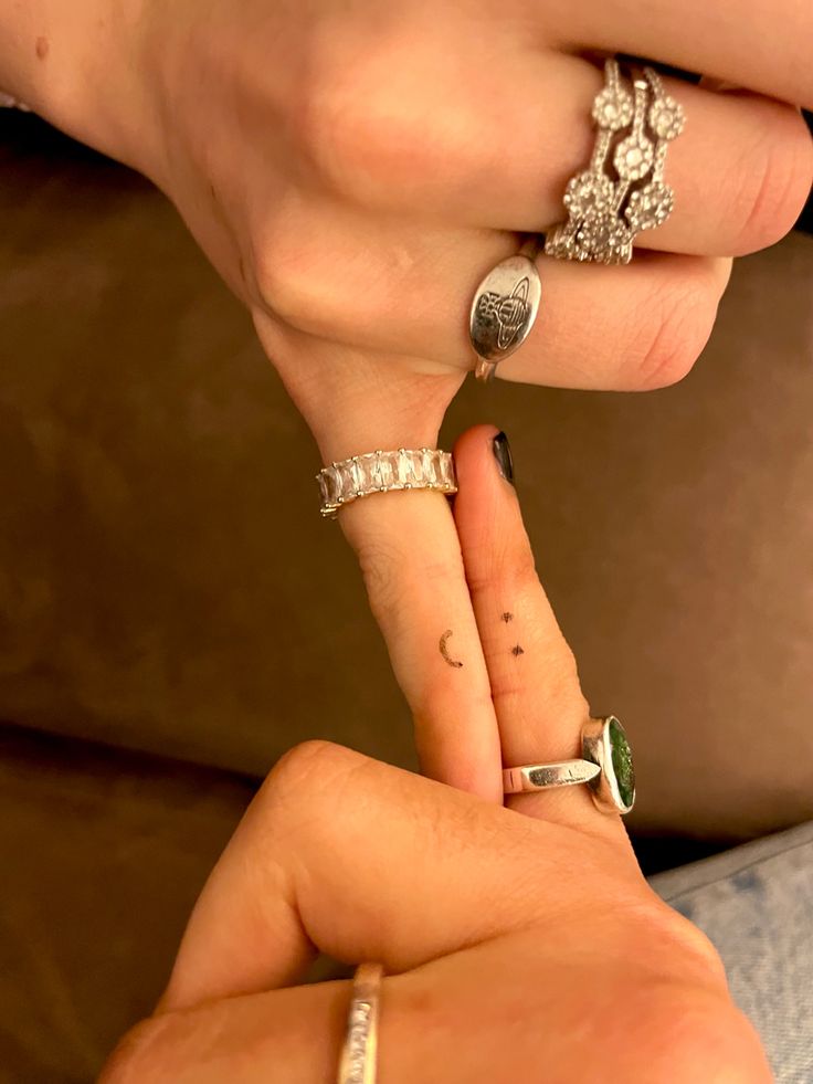 two people with rings on their fingers touching each other