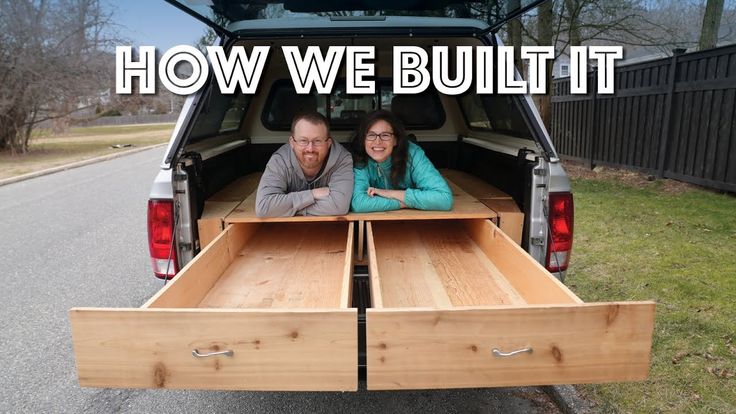 two people sitting in the back of a truck with their arms around each other's waist